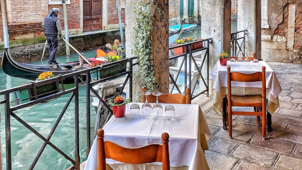 Un affascinante ristorante a Venezia situato lungo un pittoresco canale, che cattura l'atmosfera unica della città.